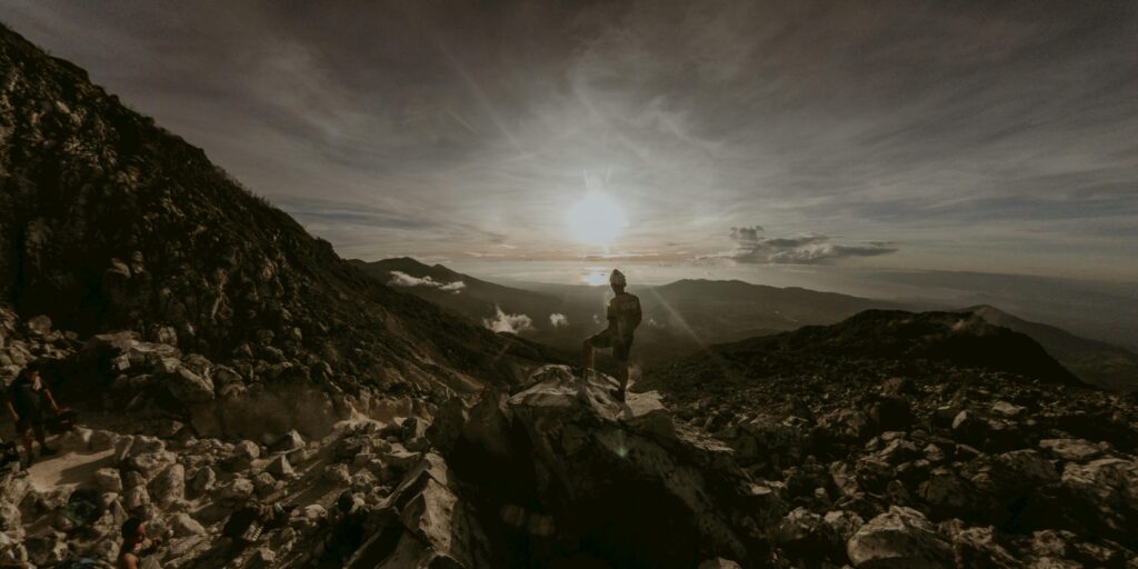 pexels-photo-14888632-14888632 Hiker standing on rocky terrain during sunrise on Mount Apo, Philippines.